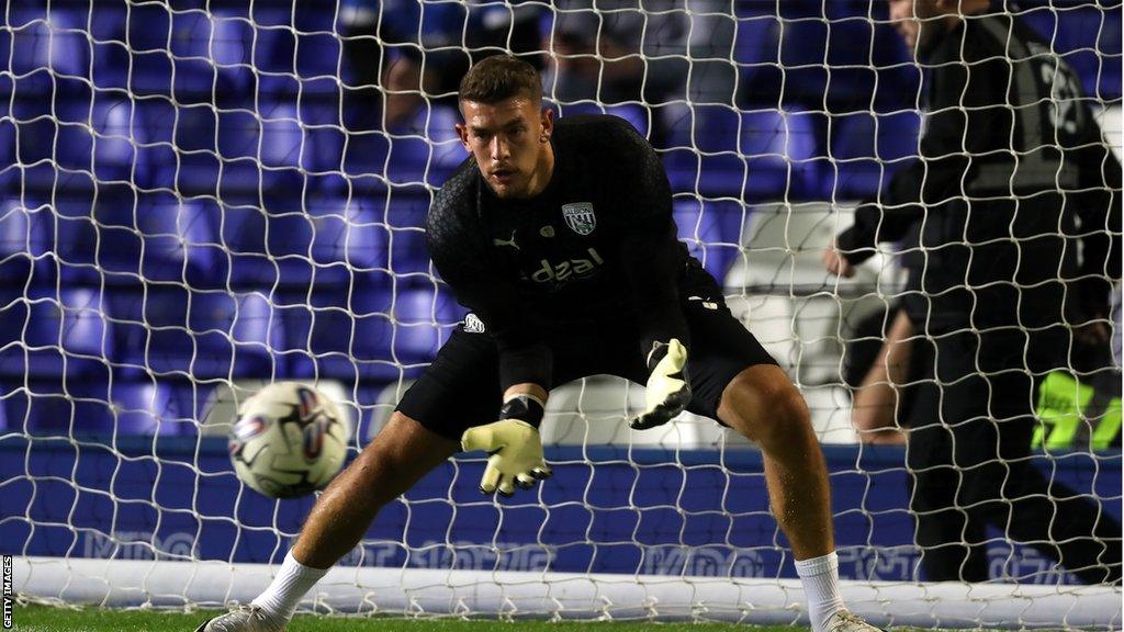 West Brom goalkeeper Alex Palmer saves a shot during warming up