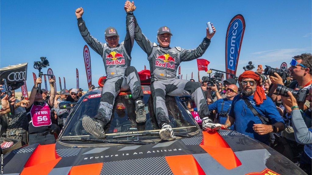 Carlos Sainz celebrating winning the Dakar Rally with Lucas Cruz