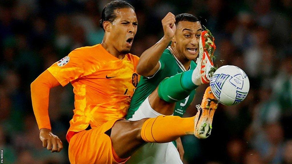 Virgil van Dijk and Adam Idah compete for the ball