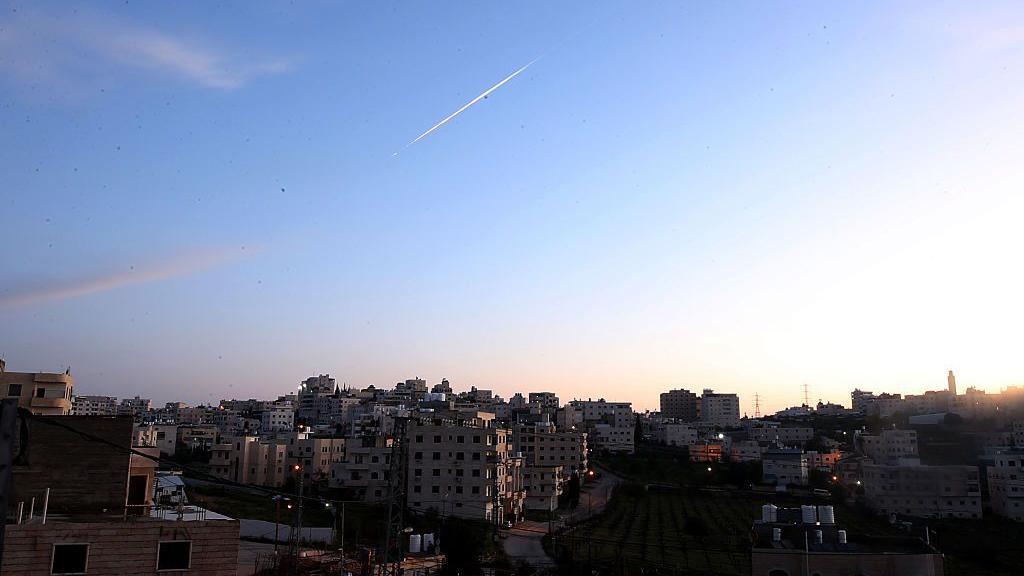 Missile in sky over city.