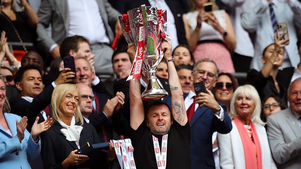 Charlton boss Nathan Jones lifting the League One play-off trophy at Wembley last season