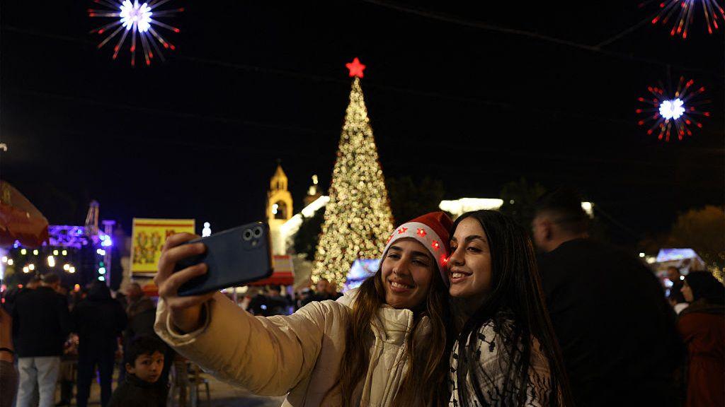 Dy gra bëjnë një foto përpara pemës së Krishtlindjeve në Sheshin e Lindjes në Betlehem, në Bregun Perëndimor të pushtuar.