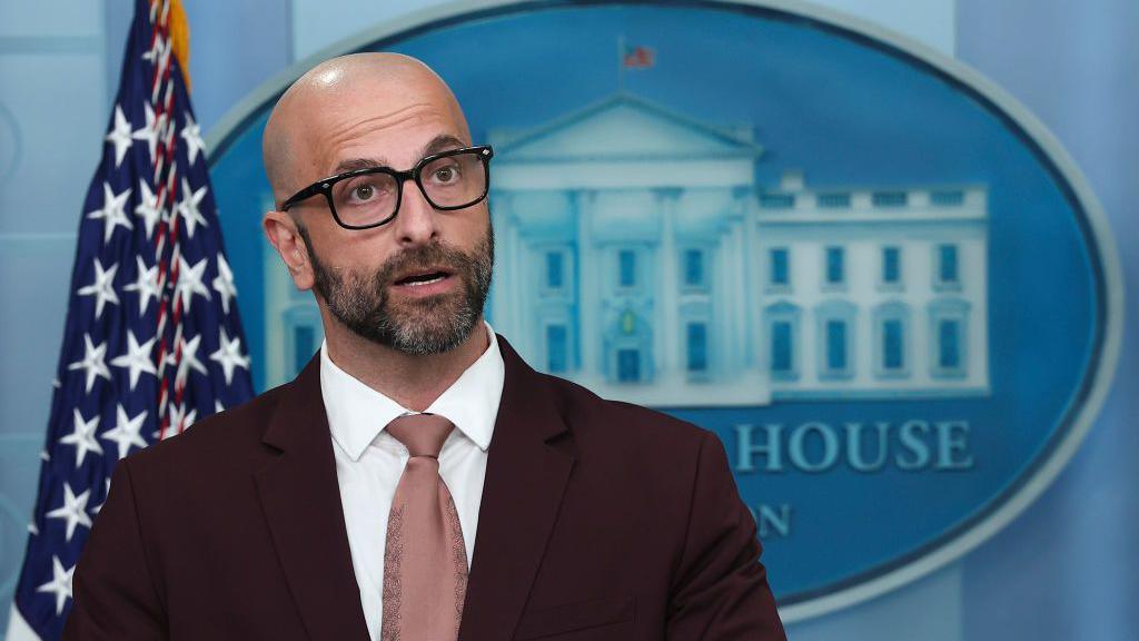 Demetre Daskalakis wears glasses and a suit in the White House briefing room