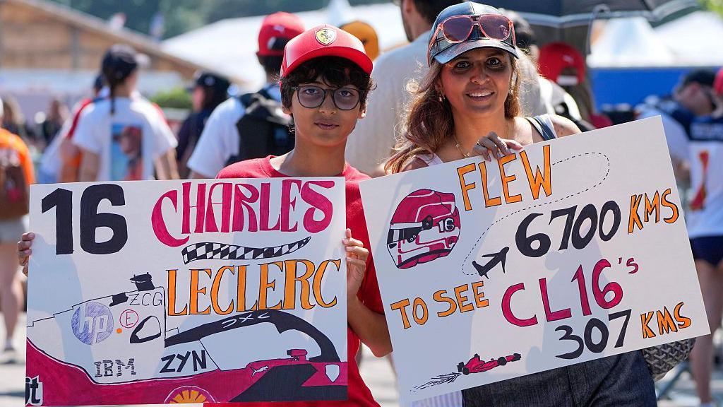 Fans hold up signs for Charles Leclerc 