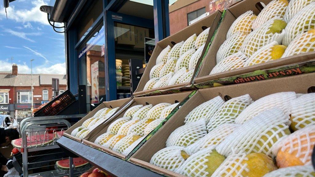 Boxes of fresh mangoes outside a grocery shop off Belgrave Road