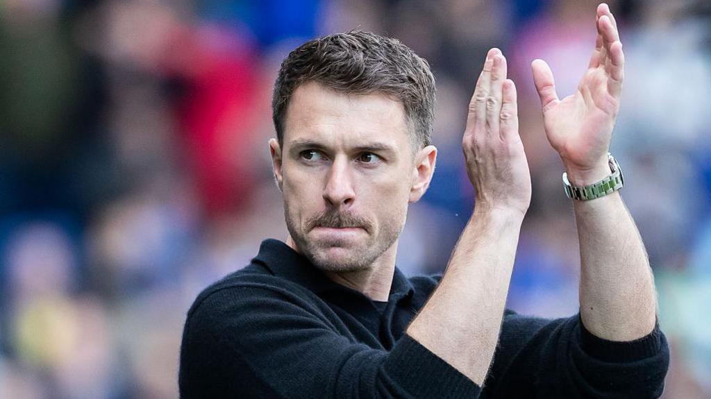 Aaron Ramsey applauds the Cardiff City fans during his time in charge as interim head coach 