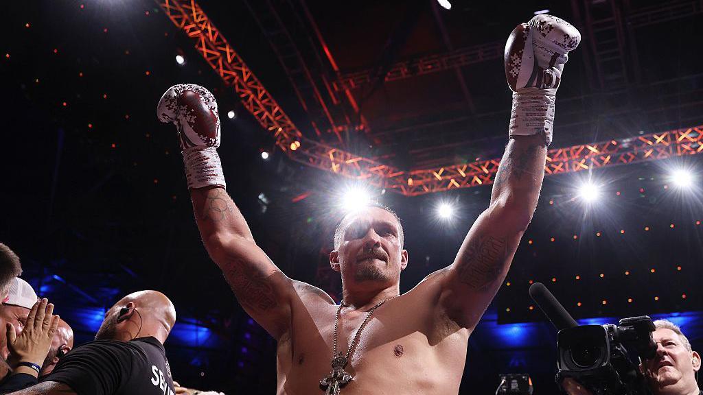Oleksandr Usyk celebrates victory over Daniel Dubois with his arms raised