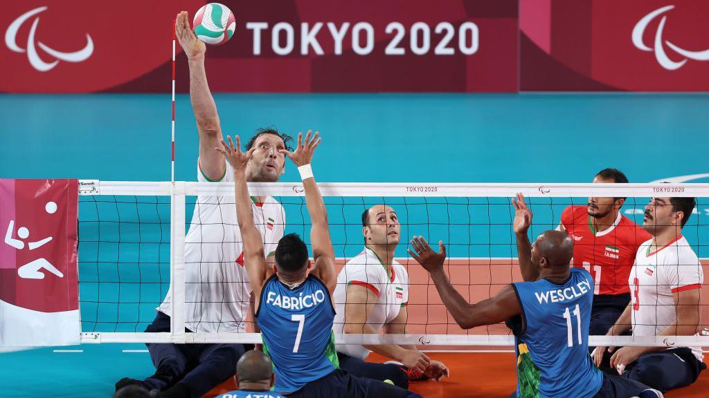 Iran and Brazil sitting volleyball teams competing. 