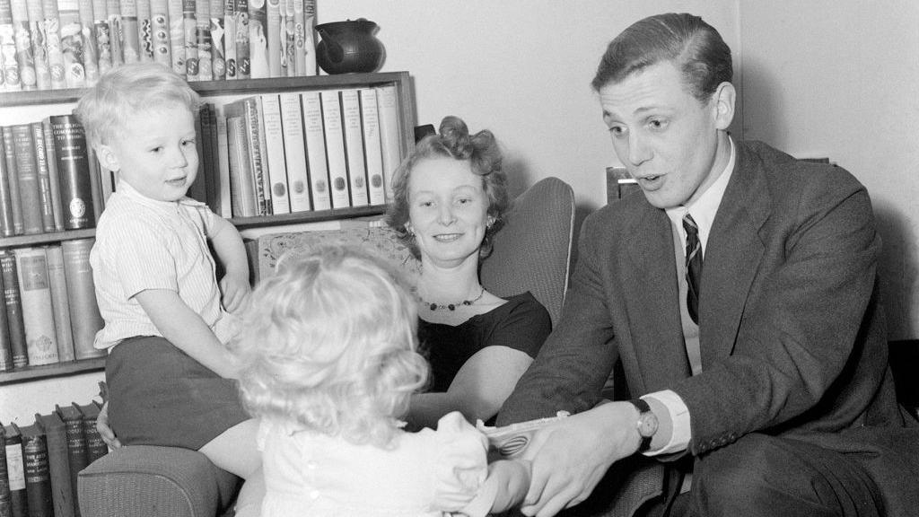 TV Presenter David Attenborough and wife Jane with their children at home, December 1955. The photograph shows the adults smiling at the children, and is shot in black and white