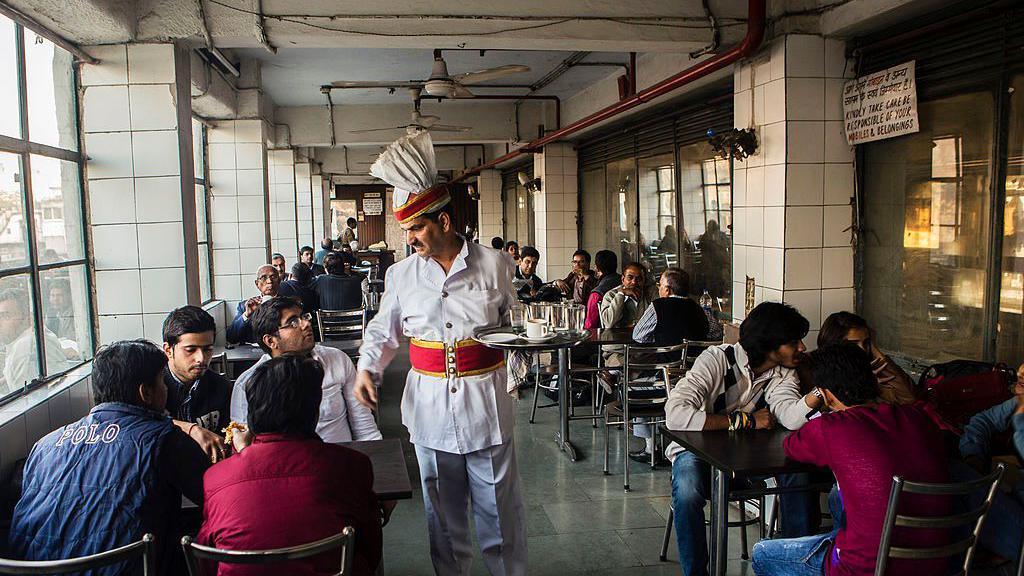 A waiter serves customers at the India Coffee House in New Delhi, India, on Thursday, Dec. 5, 2013.