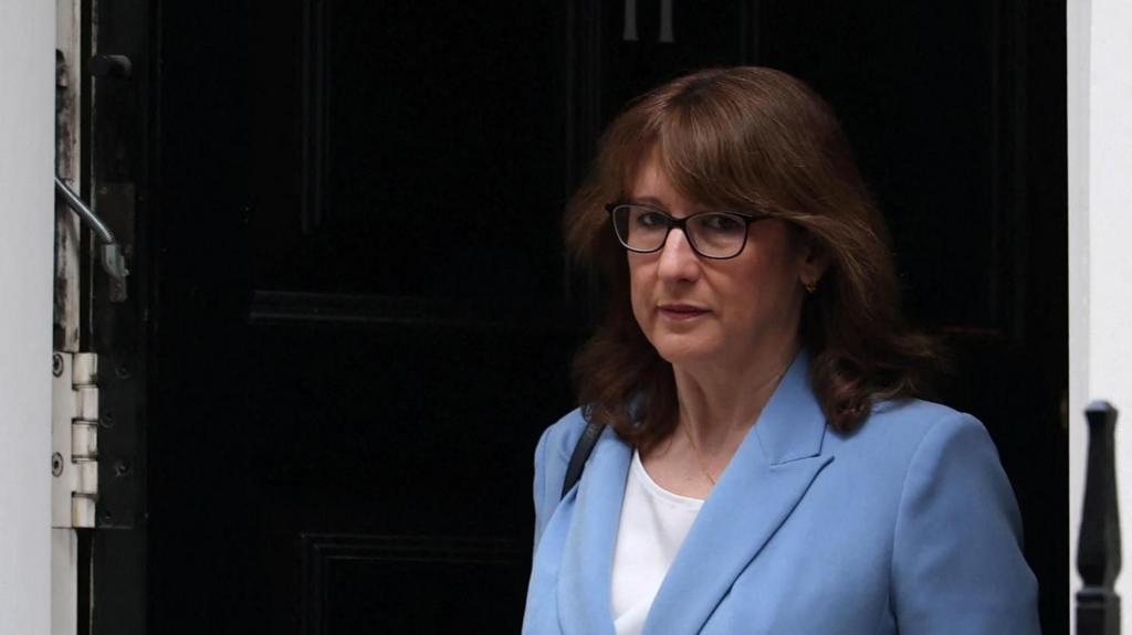 Rachel Reeves wearing a light blue suit leaving through black door of No 11 Downing Street
