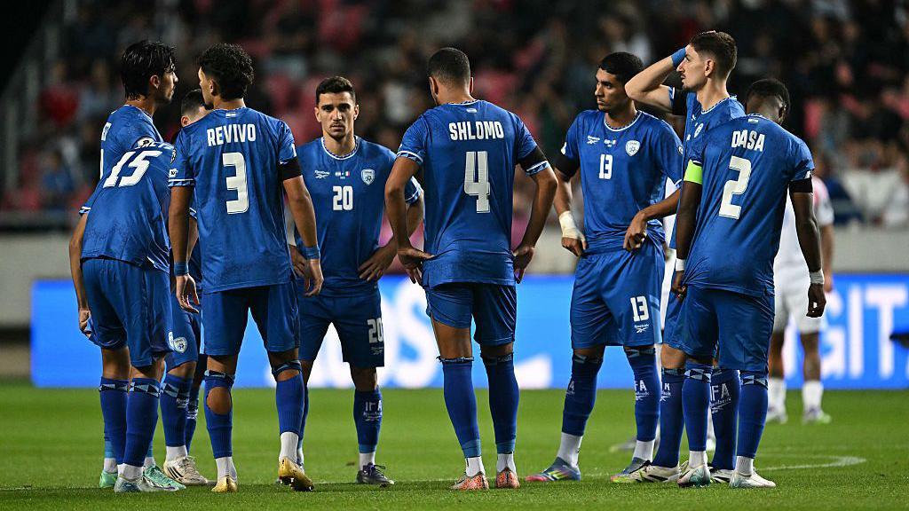 Israel national team footballers stand on the pitch during a break in play in their Fifa World Cup qualifier against Italy