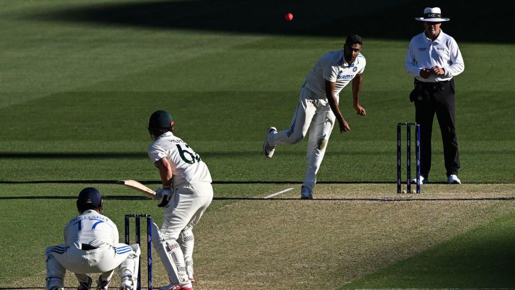 Ravichandran Ashwin bowls to Australia's Travis Head on the second day of the second Test cricket match between Australia and India at the Adelaide Oval in Adelaide on December 7, 2024.