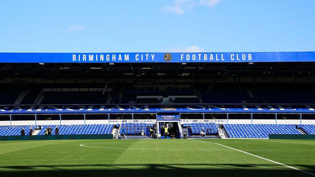 General shot of the main stand at St Andrew's showing Birmingham City Football Club across the front of the roof.