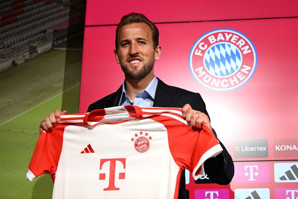 Harry Kane stands with a Bayern Munich shirt after signing for them in 2023