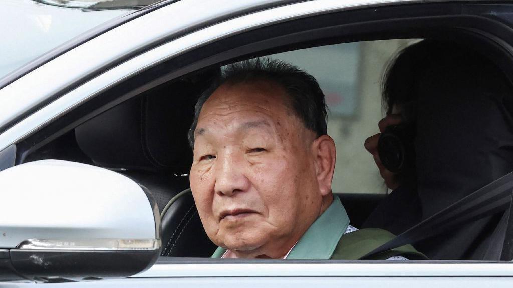 Iwao Hakamata looks out the window of a car