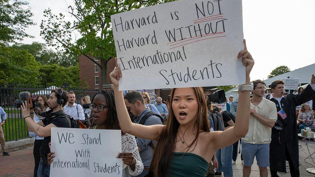 People hold up signs during the Harvard Students for Freedom rally in support of international students at the Harvard University campus in Boston, Massachusetts, on May 27, 2025