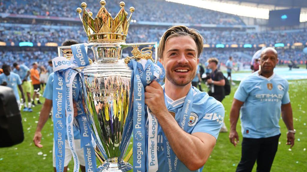 Jack Grealish celebrates with Premier League trophy