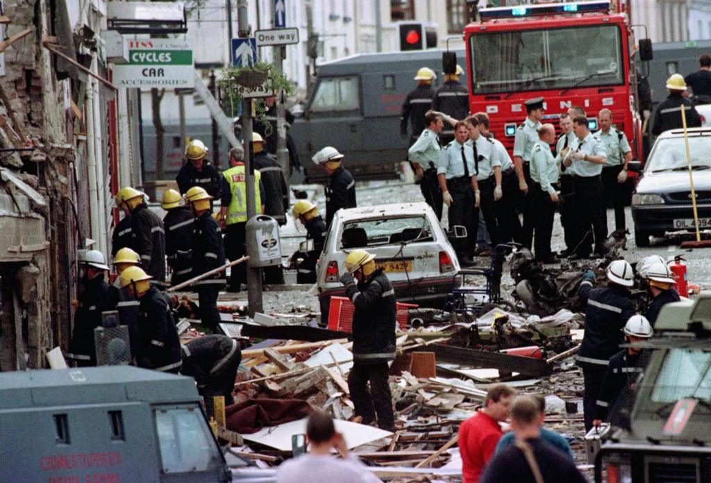 Emergency services gather in a street that is strewn with rubble