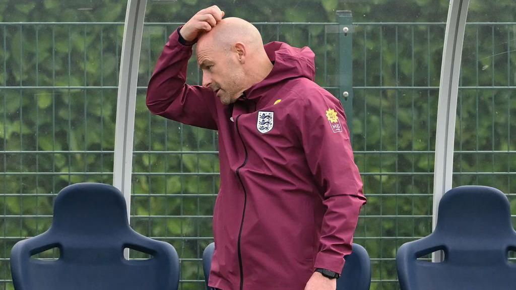 Lee Carsley scratches his head at an England training session