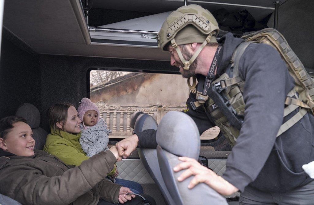 A member of the Aerial Recovery team fist-bumps one of the children being evacuated