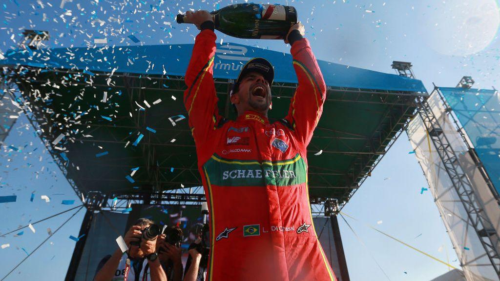 Lucas di Grassi holds a champagne bottle above his head after winning an E-prix in 2017