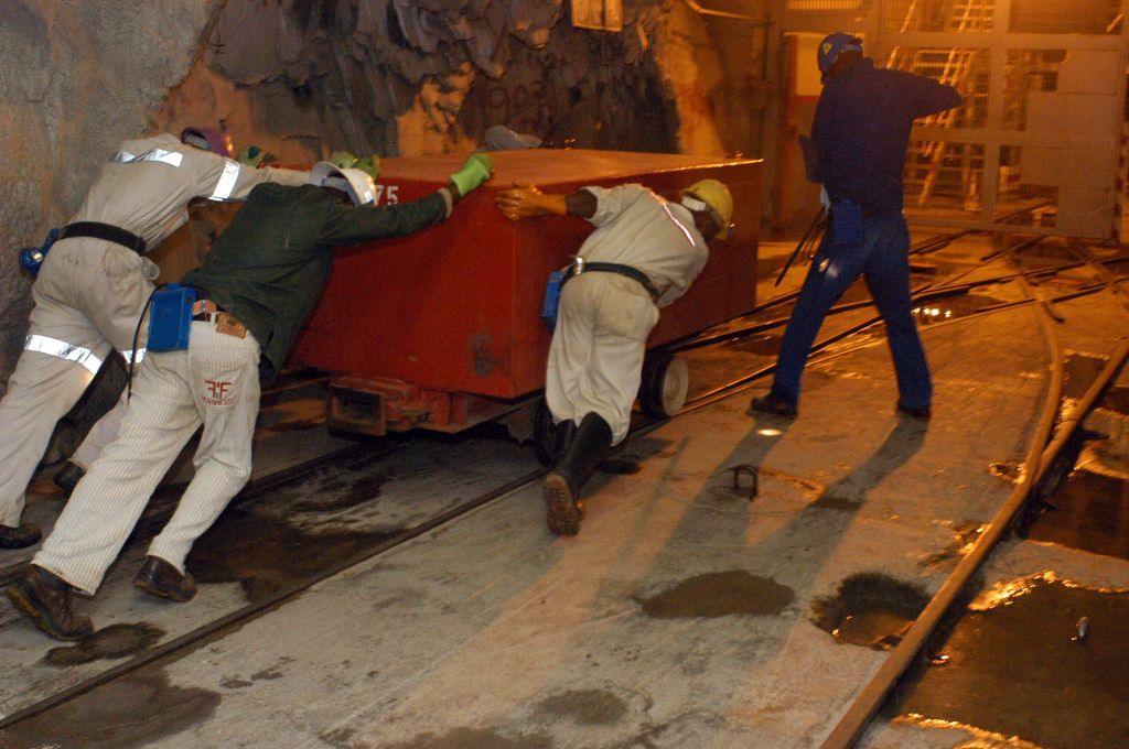 Legally employed miners push a box of explosives below ground at a gold mine in South Africa on 27 October 2005