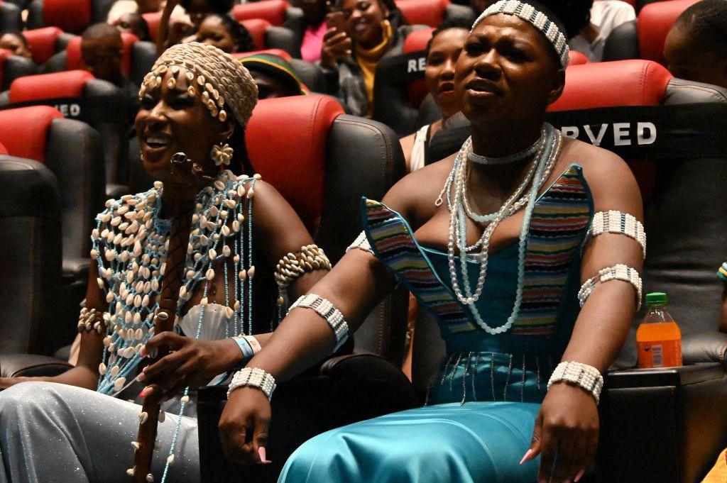 Two women smile and frown in a cinema.