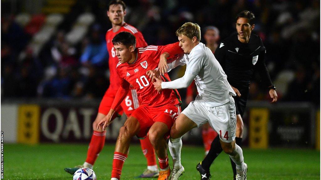 Rubin Colwill of Wales is tackled by David Kruse of Denmark