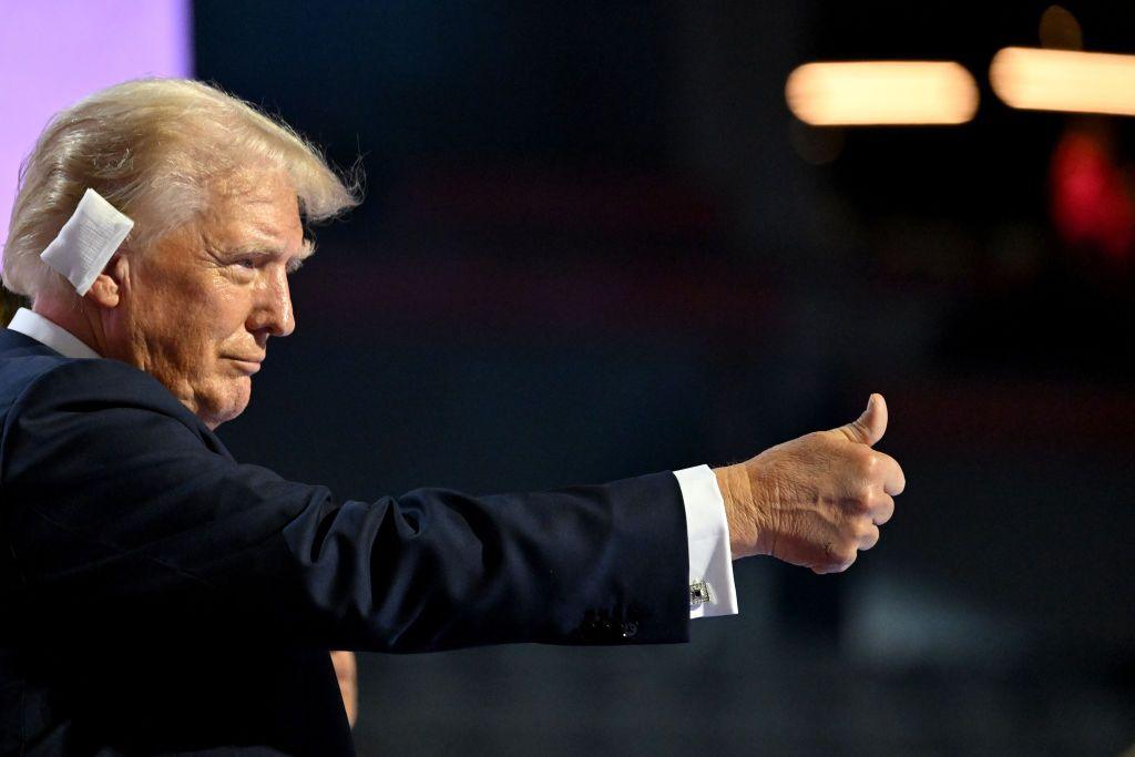 Donald Trump gives a thumbs up to the crowd at the Republican National Convention in Milwaukee. He has a white bandage on his right ear.