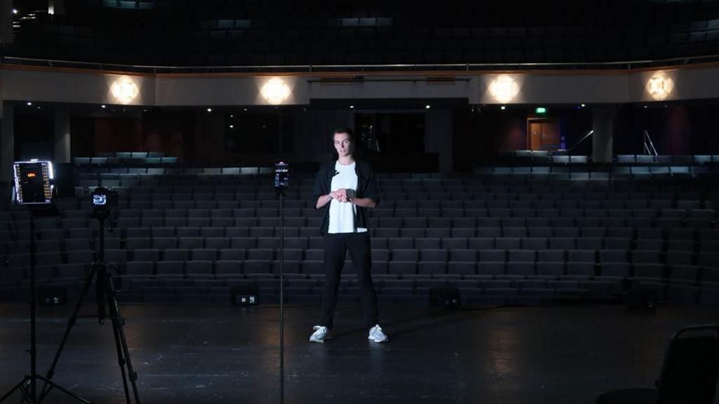 William Laven on stage at New Victoria Theatre in Woking delivering a speech