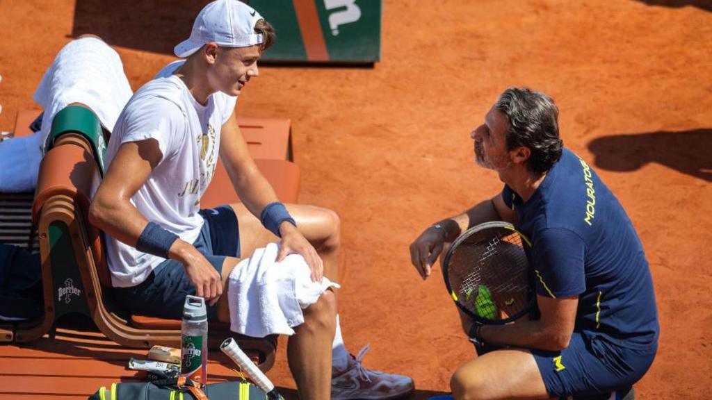 Holger Rune of Denmark speaking to coach Patrick Mouratoglou during a French Open practice session