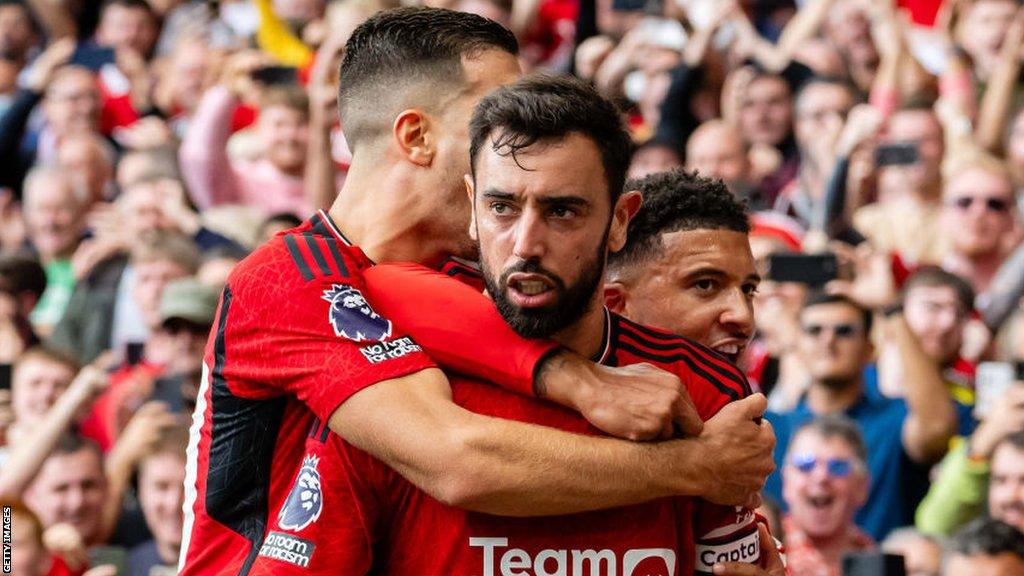 Bruno Fernandes celebrates with Diogo Dalot and Jadon Sancho after scoring from the penalty spot in Manchester United's comeback victory over Nottingham Forest