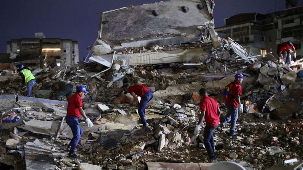 Responders search for victims in a demolished building at San Bernardino