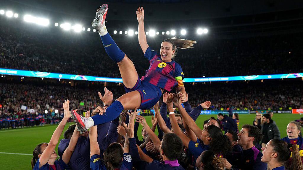 Alexia Putellas being thrown in the air in celebration by team mates and staff following her 500th club appearance in 2026.