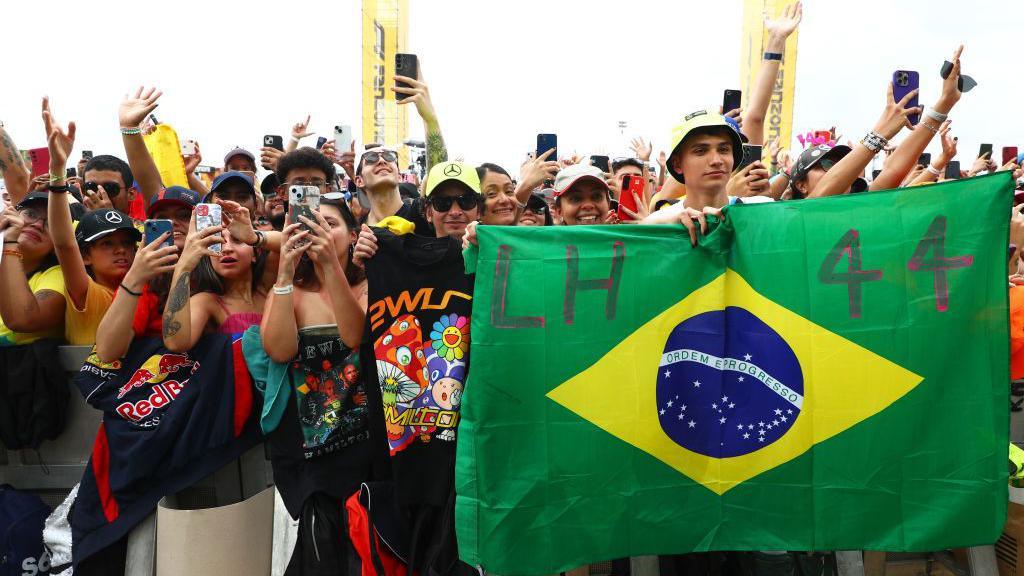 Fans hold up their phones and a Brazilian flag with 'LH 44' during last year's race at Interlagos