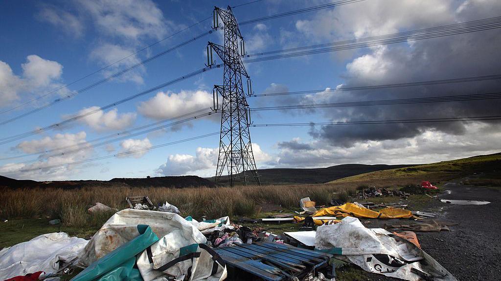 Sbwriel wedi'i adael dan beilonau trydan ger Merthyr Tydfil