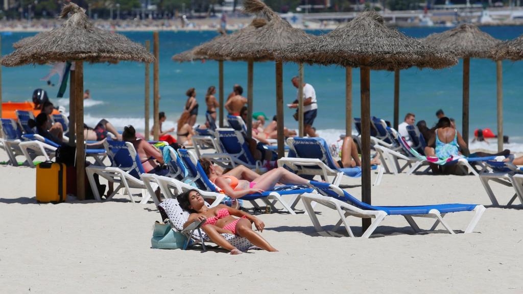 People sunbathe in Magaluf beach