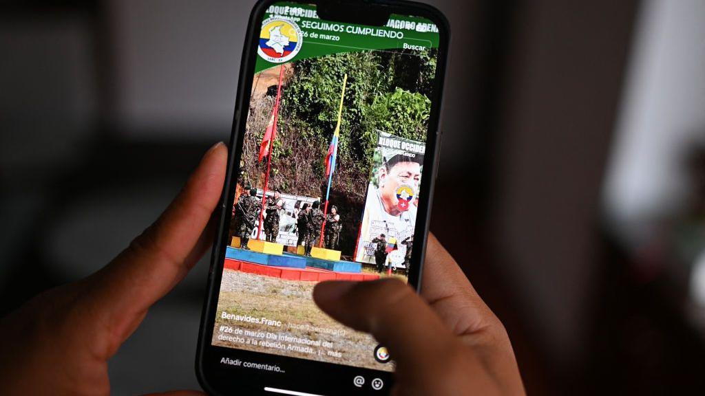 A woman looks at the TikTok account of a dissident member of the Farc