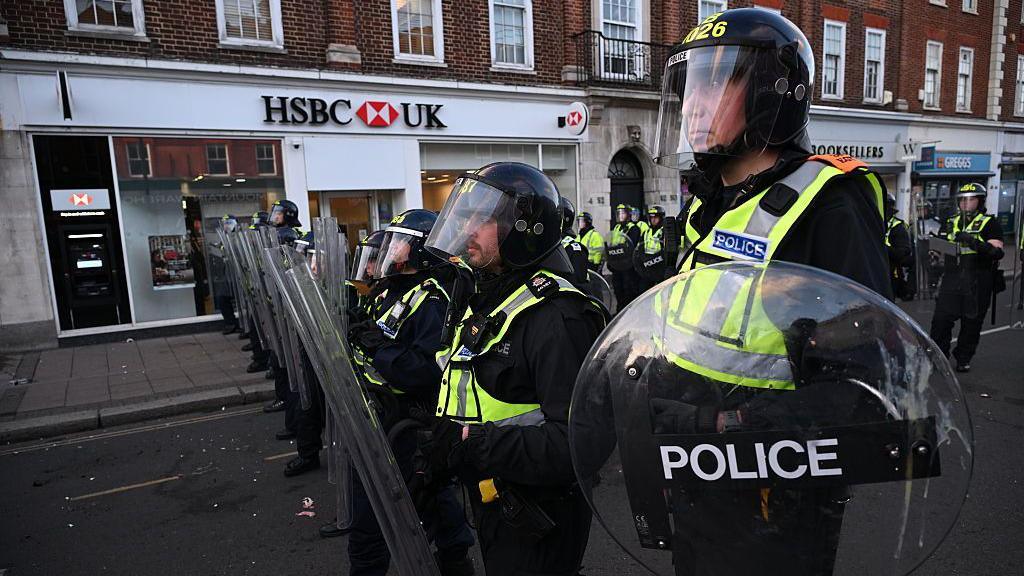 Riot police are seen on Epsom high street.