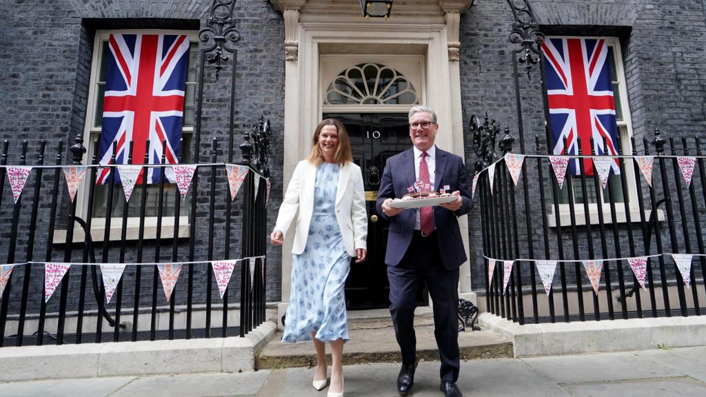 The prime minister and his wife bring cakes to a street party on Downing Street