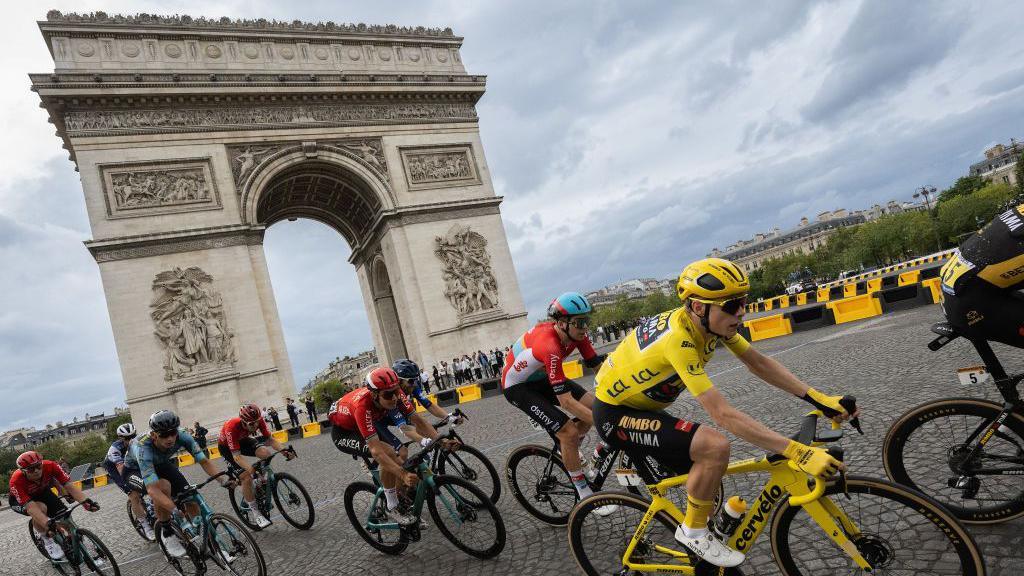 TdF cyclist going past the Arc de Triomphe.