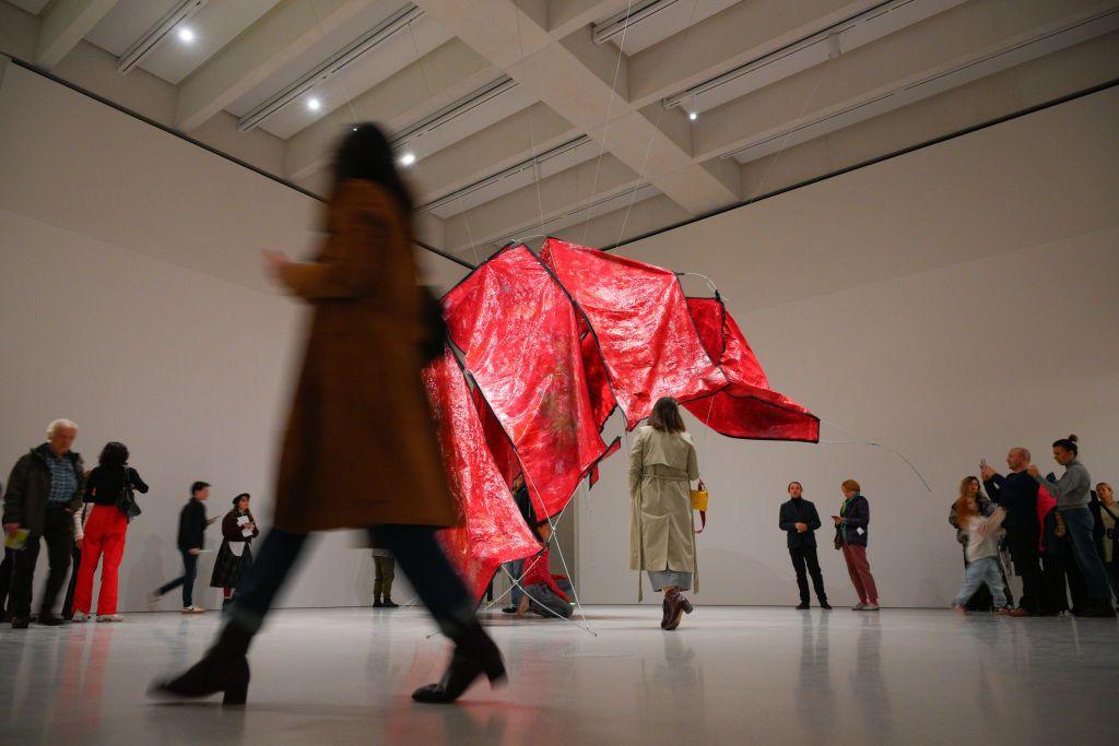 Visitors observe the red sculpture "Ghosting" by Congolese artist Sandra Mujinga at the opening of the new Museum of Modern Art in Warsaw.