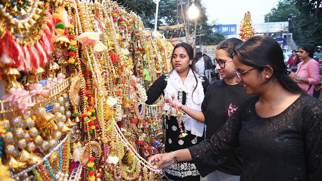 A group of girls looking at gifts at a market.