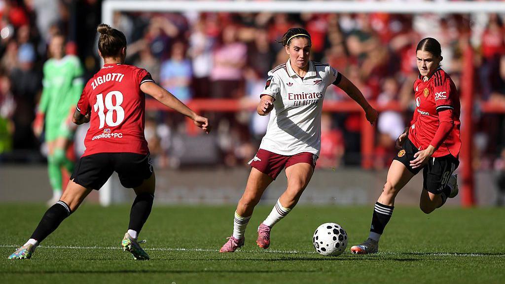 Manchester United and Arsenal players battle for possession during their WSL game at Leigh Sports Village