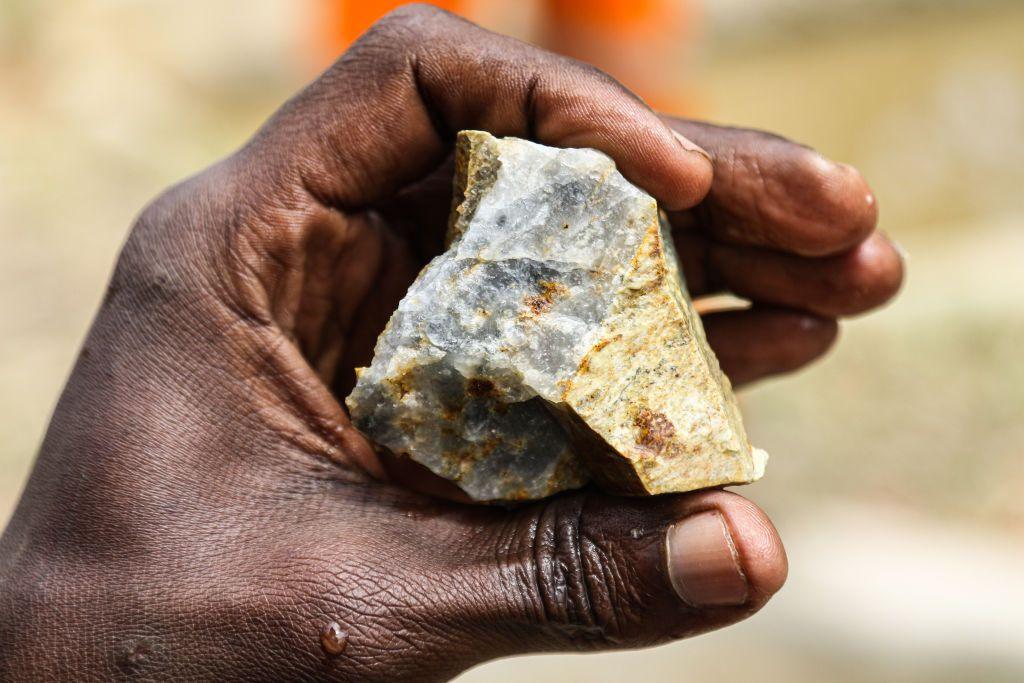 A man's hand holding ore at a gold mining village Mikai, Kenya.