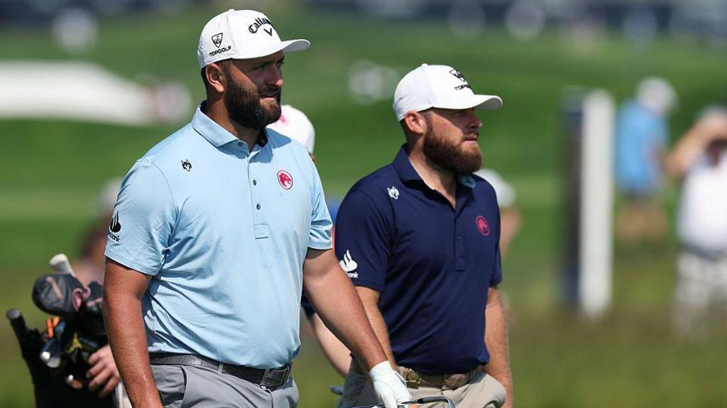Jon Rahm and Tyrell Hatton look on