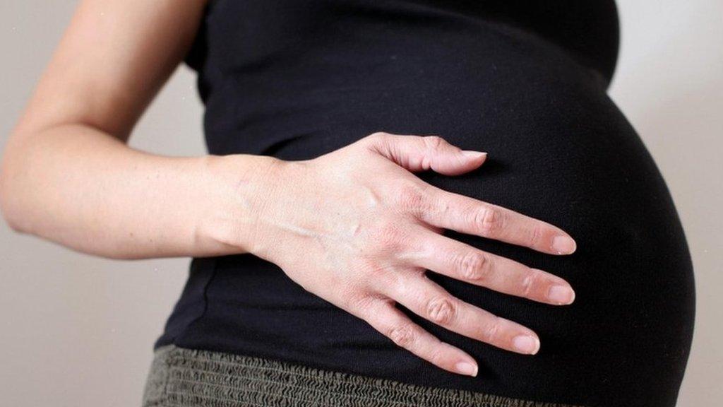 Pregnant woman holding her stomach