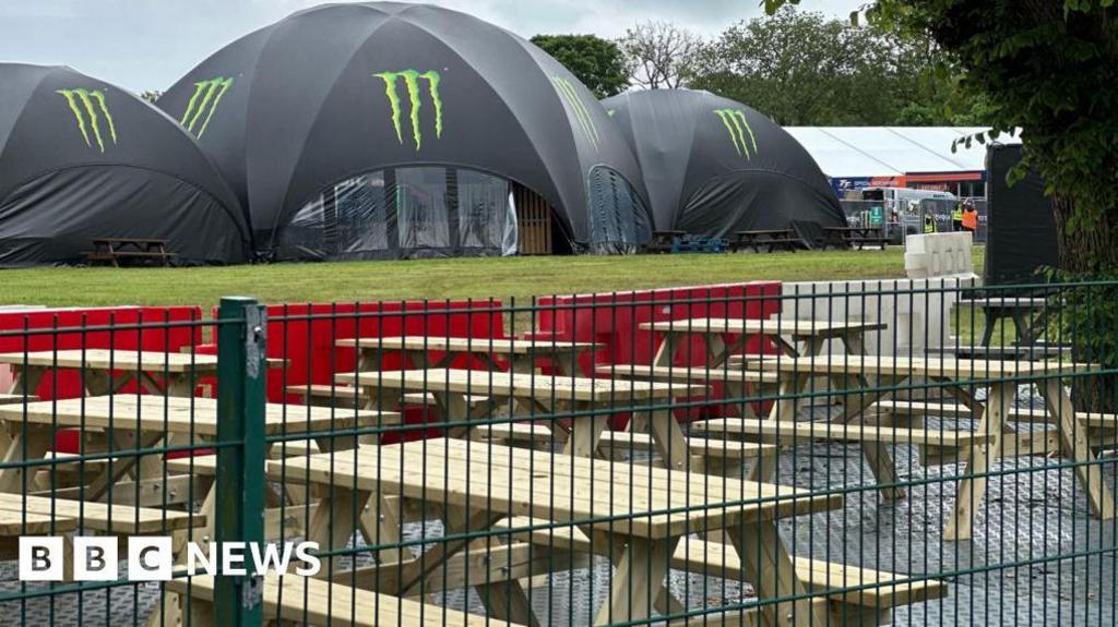 The TT fan park at Noble's Park with one large tent and benches behind a fence.