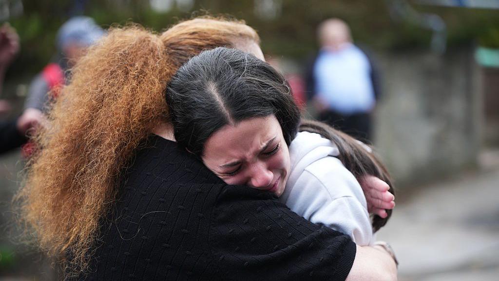 : Members of the public react as they gather near the Heaton Park Hebrew Congregation Synagogue, where multiple were injured after stabbing and car attack on Yom Kippur, on October 2, 2025 in the Crumpsall suburb of Manchester
